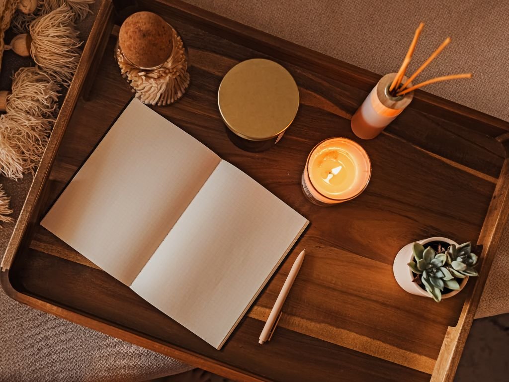 A weekly planner sitting on a tray with calming accessories like incense and candles to discover calm planning